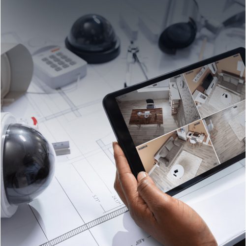 Sistema de CFTV sendo monitorado por tablet sobre o projeto técnico